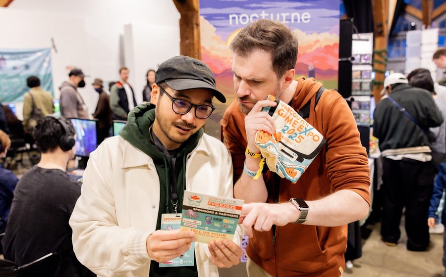 Two attendees reading a Vancouver Game Expo handout